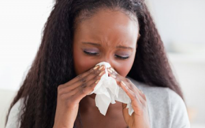 Female using tissue to blow her nose