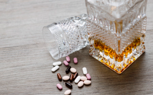 Pills and bottle of alcohol on a table