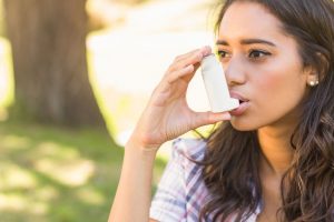 Lady in park using inhaler