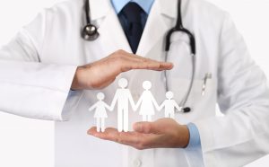 Doctor protecting paper cut-out depicting family