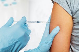 Nurse injects needle into patient's arm