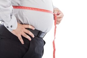 Overweight male with tape measure around his waist